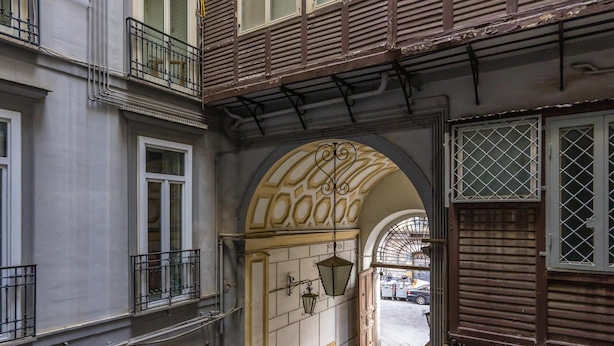 A narrow alleyway between buildings with a wooden door and a metal gate. - Rosaroll 70 Apartment by Wonderful Italy (Naples)