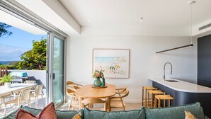 A modern kitchen with a built-in sink and a dining area with wooden furniture.