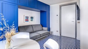 A modern living room with a grey sofa, a white coffee table, and a blue accent wall. - Le Arcate Giuliana by Feeling Italy (Massa Lubrense)
