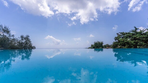 A clear blue pool with a view of the ocean and trees on both sides. - Le Arcate Giuliana by Feeling Italy (Massa Lubrense)