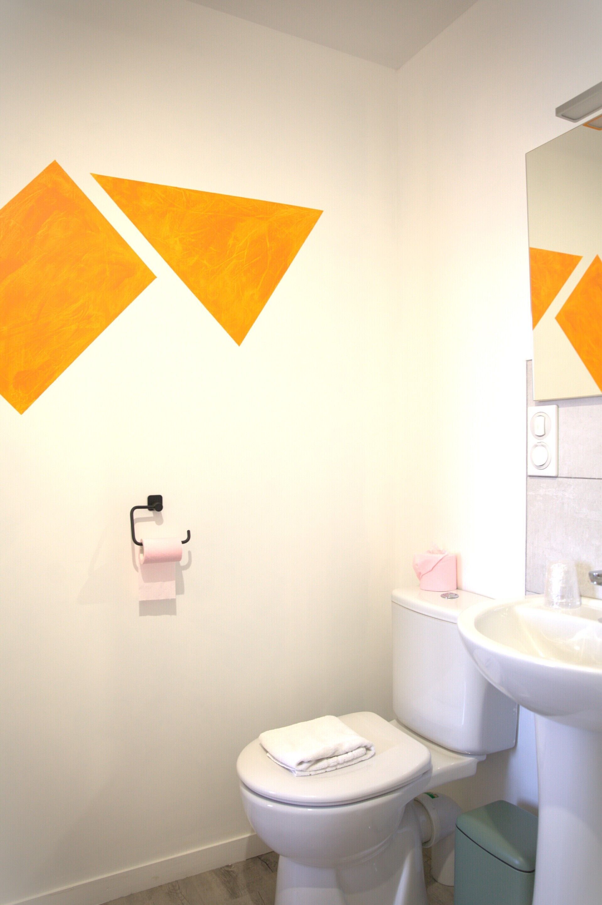 A modern bathroom with a toilet, sink, and towel rack.