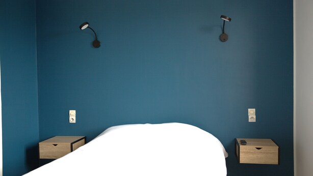 A bedroom with a single bed, two bedside tables, and two wall-mounted lamps. - Relais 375 (Valence-en-Poitou)