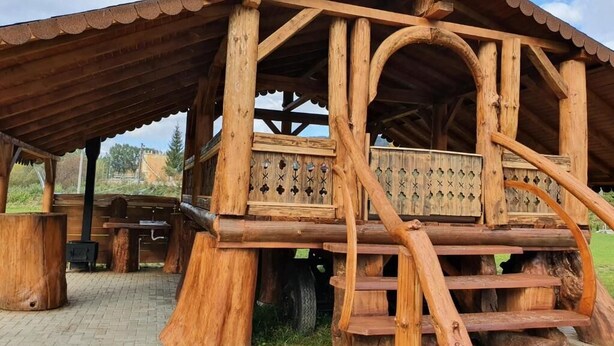A rustic wooden structure with a covered porch and a staircase leading to an upper level. - CASA SIADY (Vatra Dornei)