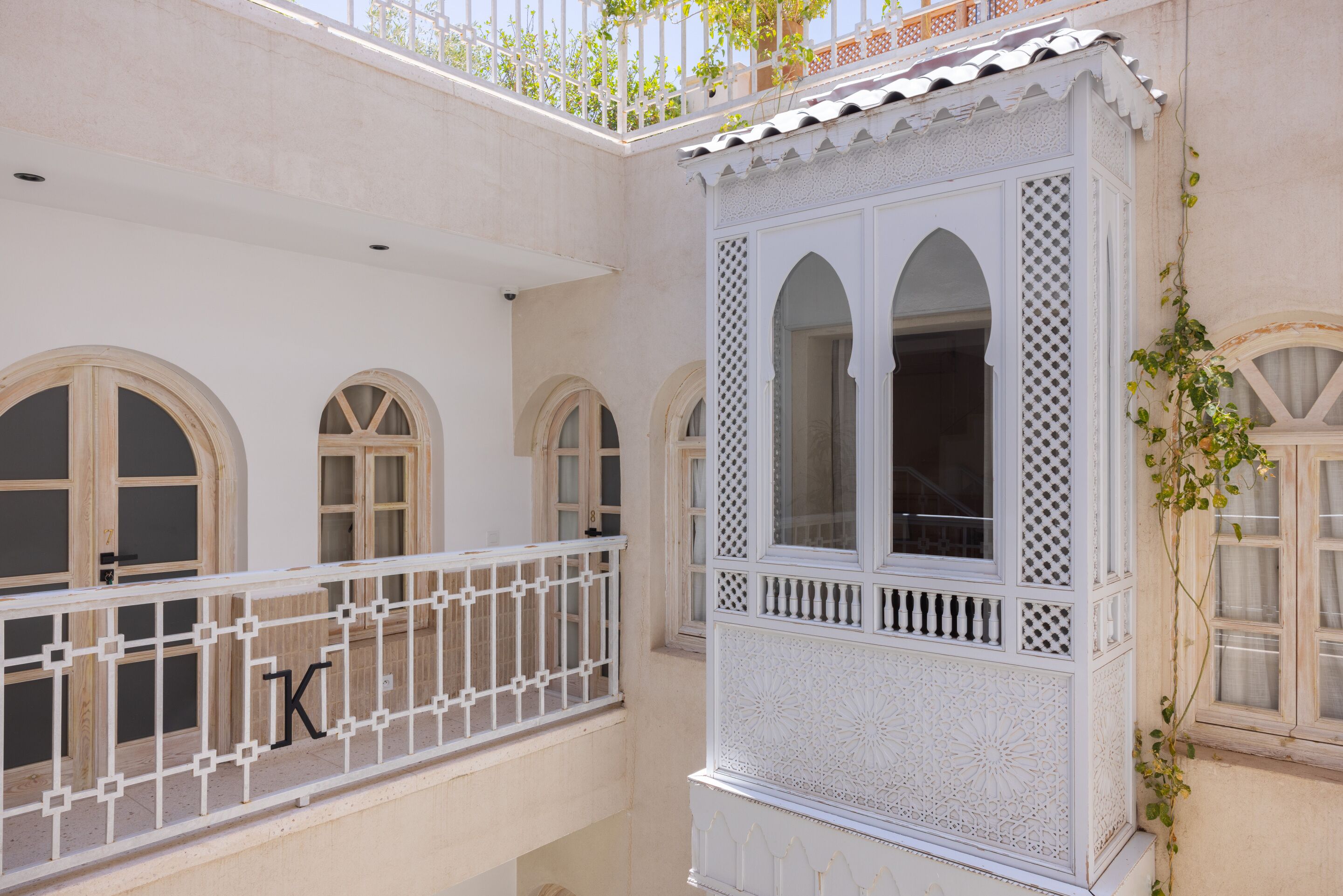 A traditional building with arched windows and a balcony with a white railing.