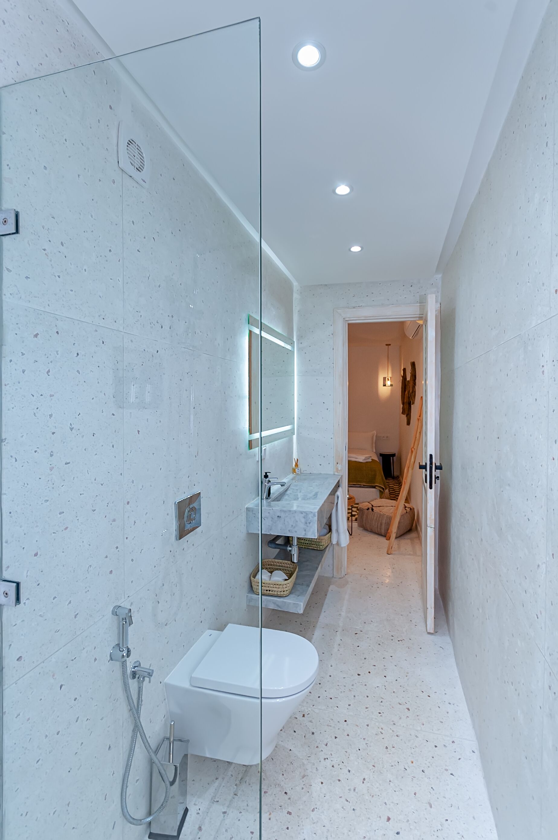 A modern bathroom with a glass shower enclosure, a white sink, and a toilet.