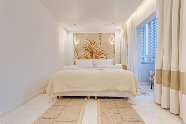 Un dormitorio moderno con una cama grande, una pared decorativa y vistas al exterior.