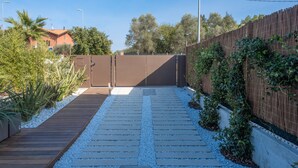 A pathway leading to a gated entrance with a wooden deck and white gravel. - Onda 8, Emma Villas - Four Bedroom Villa, Sleeps 8 (Scacciano)