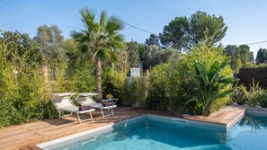A swimming pool with wooden deck and lounge chairs, surrounded by dense greenery and trees. - Onda 8, Emma Villas - Four Bedroom Villa, Sleeps 8 (Scacciano)