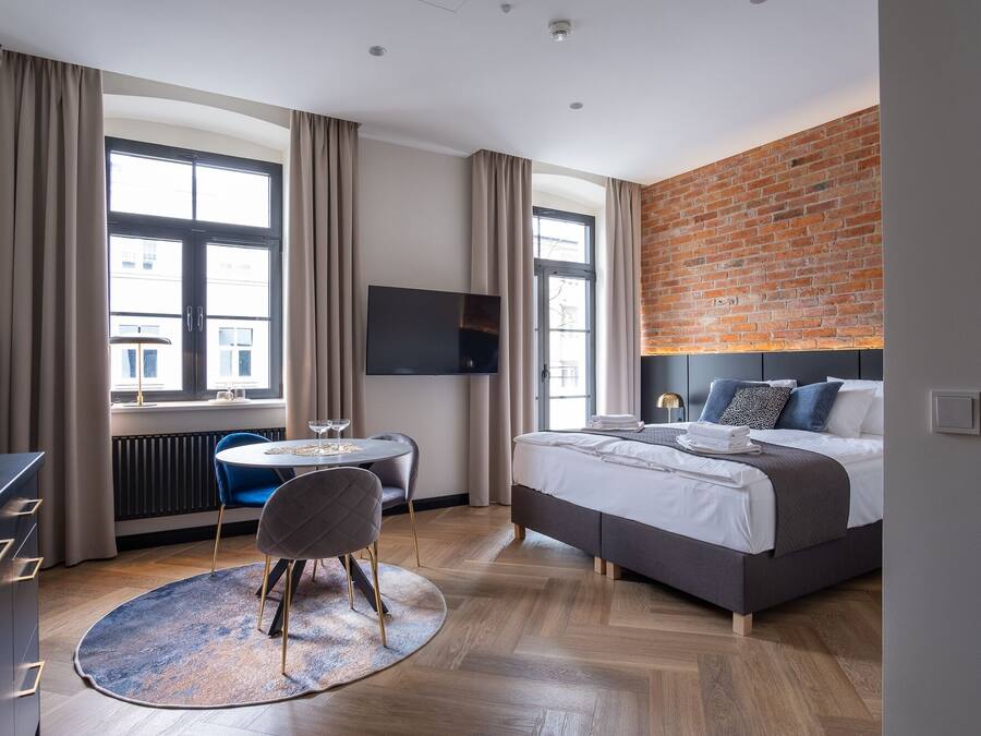 Une chambre d’hôtel moderne, dotée d’un grand lit, d’un bureau et d’un coin repas.