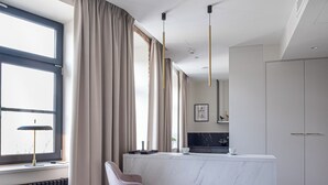 A modern kitchen with a marble island, pendant lights, and a view of the city. - Carvala Boutique Apartments (Czestochowa)