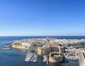 Une ville côtière dotée d’un port fortifié, de bâtiments historiques et offrant une vue dégagée sur la mer.