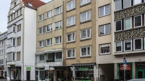 Un edificio a più piani con un caffè al piano terra e un'indicazione di parcheggio.