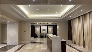 Un hall d’hôtel comprenant un comptoir d’accueil, un espace salon et une grande fenêtre.
