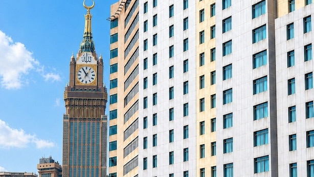 Un hôtel moderne, situé dans un immeuble de grande hauteur, avec un beffroi en arrière-plan.