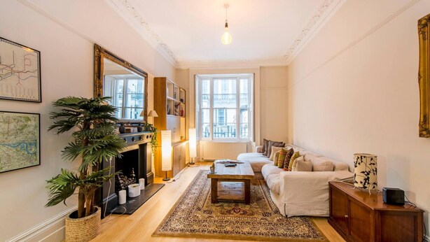 A spacious living room with a fireplace, a large window, a sofa, and a coffee table.
