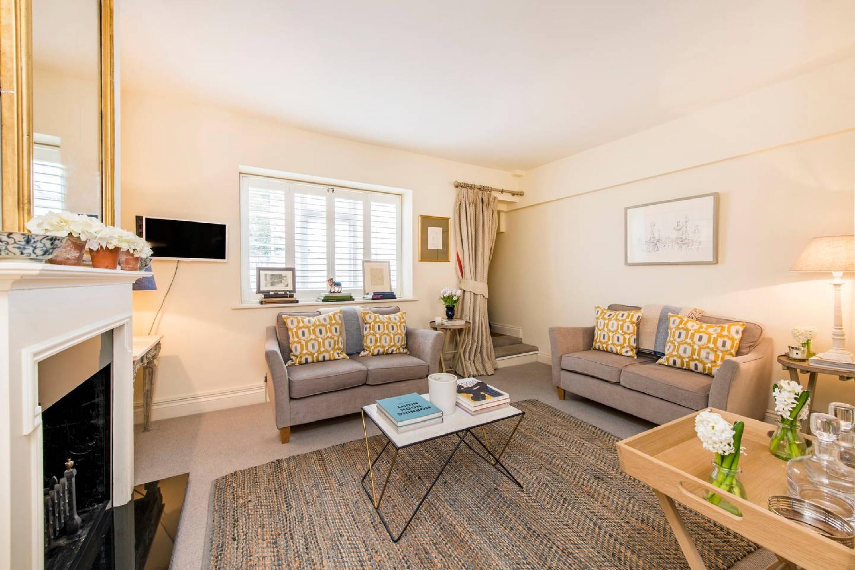 A living room with two sofas, a coffee table, a fireplace, and a TV.