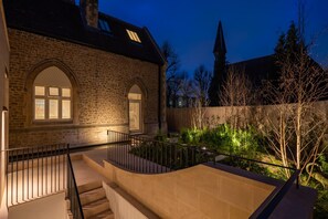 Ein Gebäude aus Stein mit einer Treppe und einem Garten.