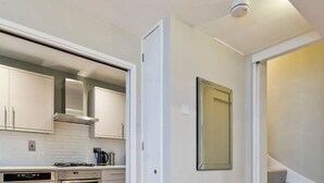 A compact kitchen with modern appliances, a small table, and a staircase leading to another level. - Sweet Marble Arch 2 Bedroom Mews House (London)