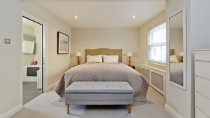 A bedroom with a bed, bench, bedside tables, a mirror, and a window. - Sweet Marble Arch 2 Bedroom Mews House (London)