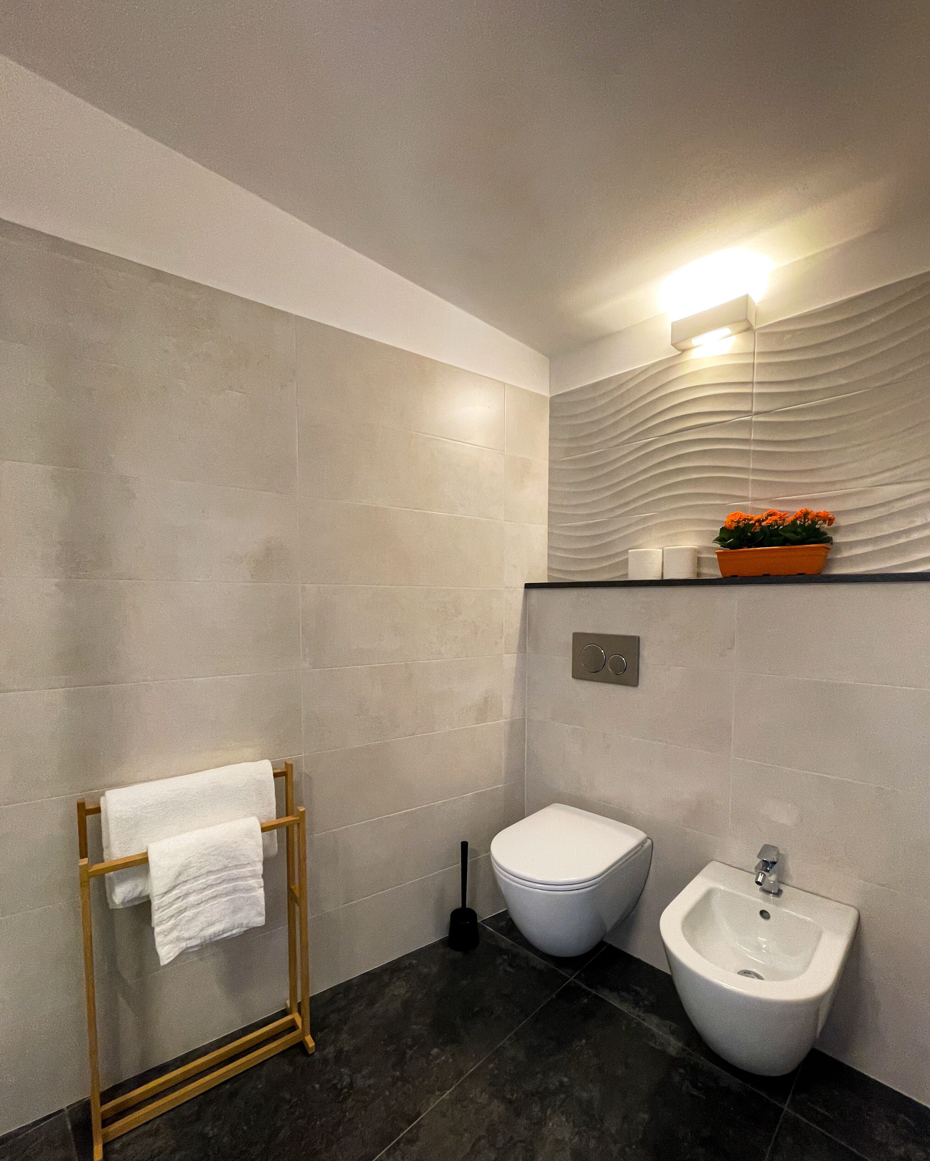 Un baño moderno con inodoro, bidé y toallero.
