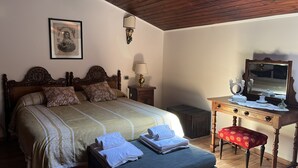 A neatly made bed with floral pillows, a bedside lamp, and a mirror on a dresser. - Sea View Flat (Giardini Naxos)