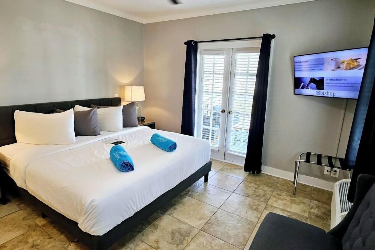 A hotel room with a bed, a TV, a desk, and a chair.