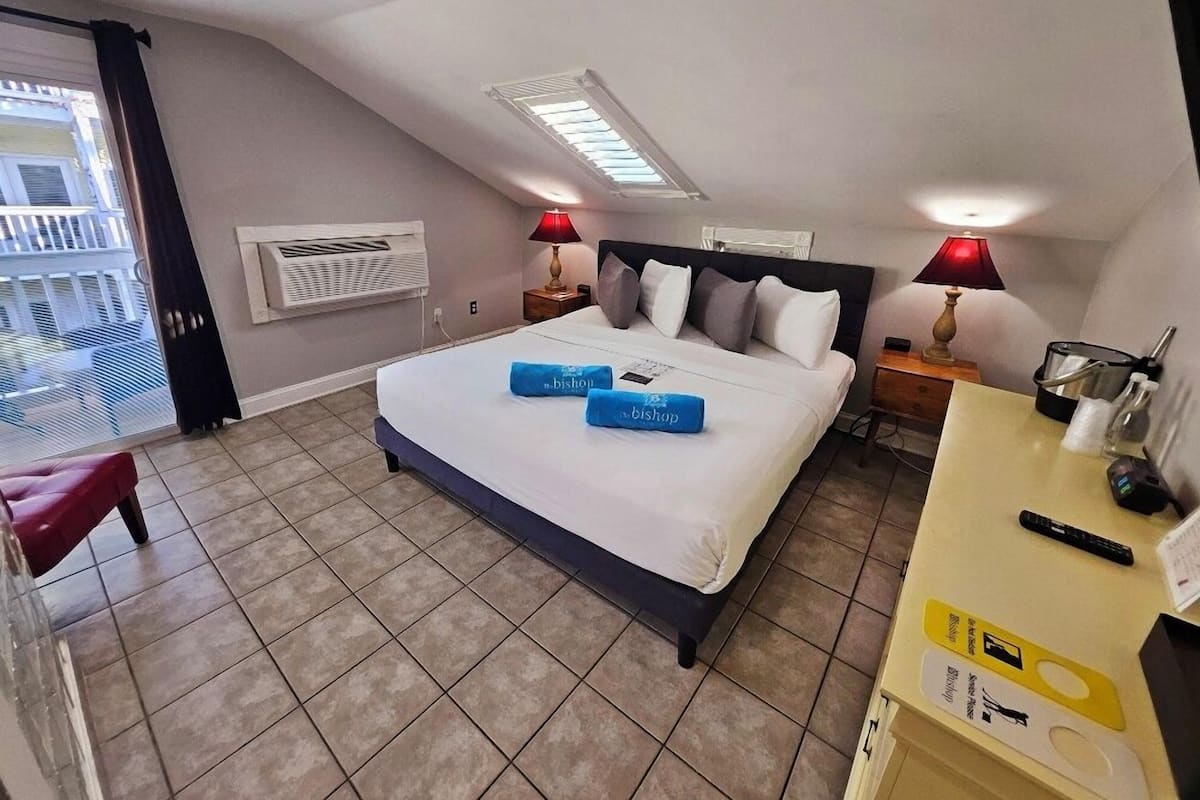A hotel room with a bed, two nightstands, a desk, and a chair.