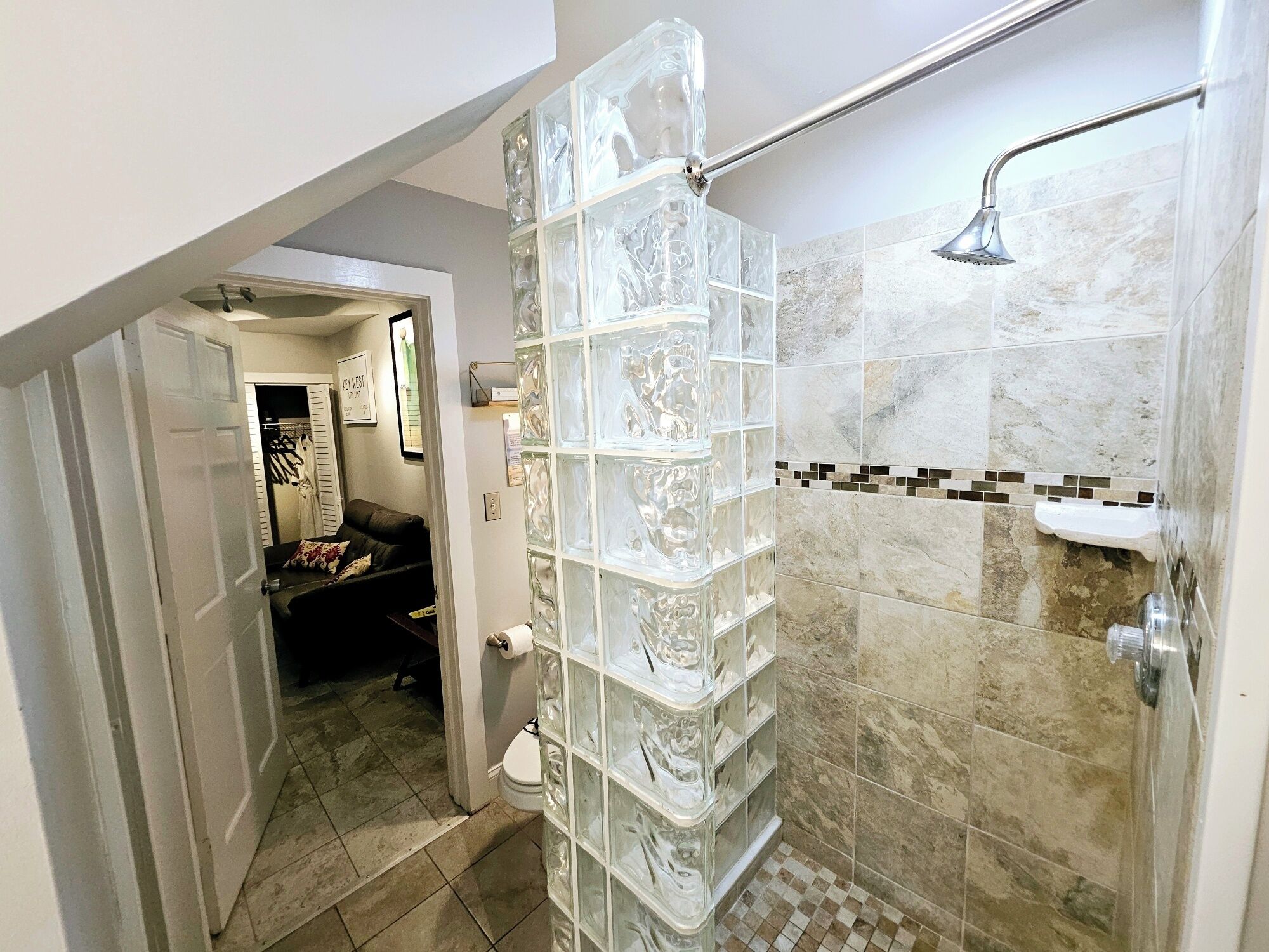 Ein modernes Badezimmer mit Duschkabine aus Glas, begehbarer Dusche und Fliesenboden.