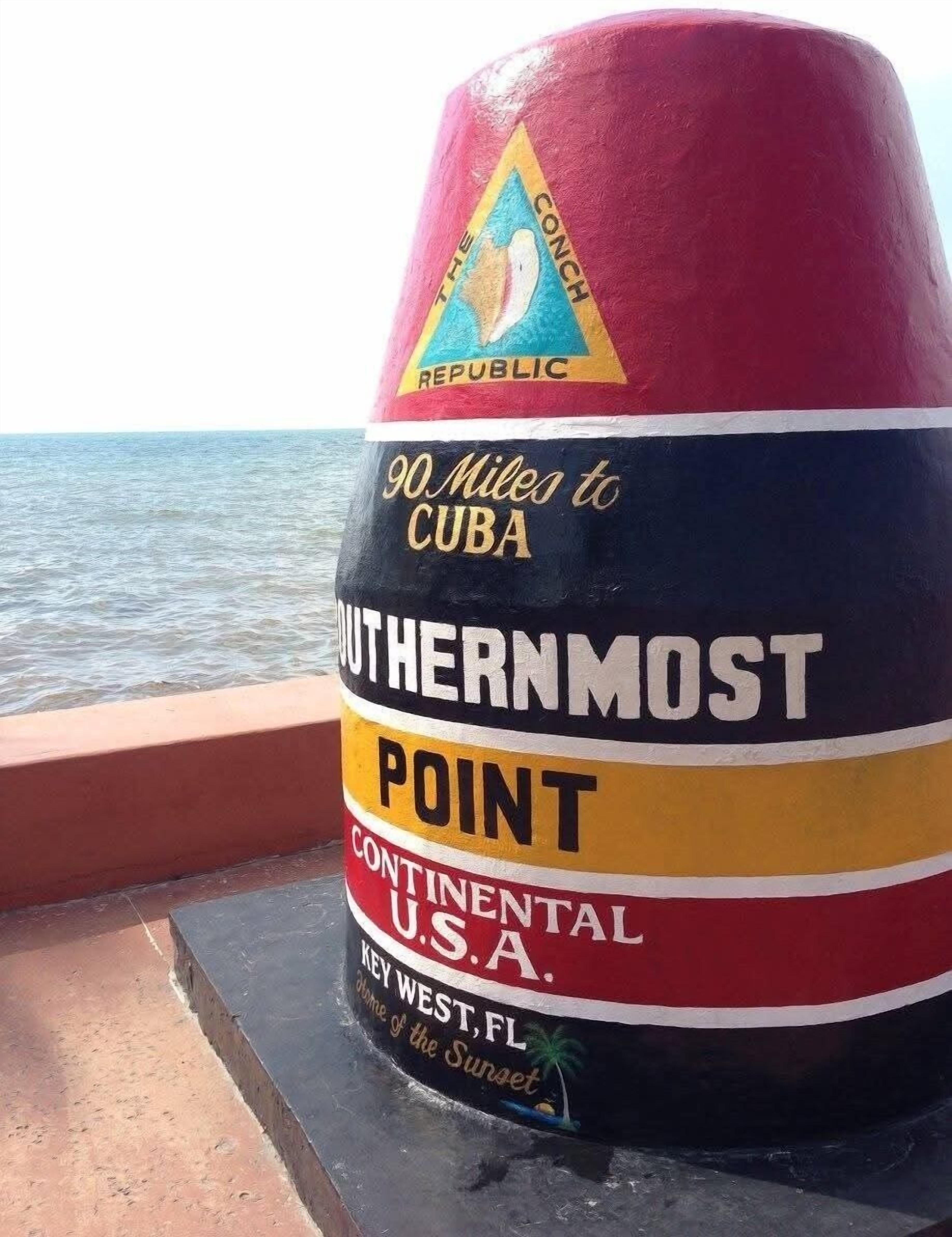 A painted marker on a boat with text indicating it is the Southernmost Point in the Continental U.S. and 90 miles to Cuba.