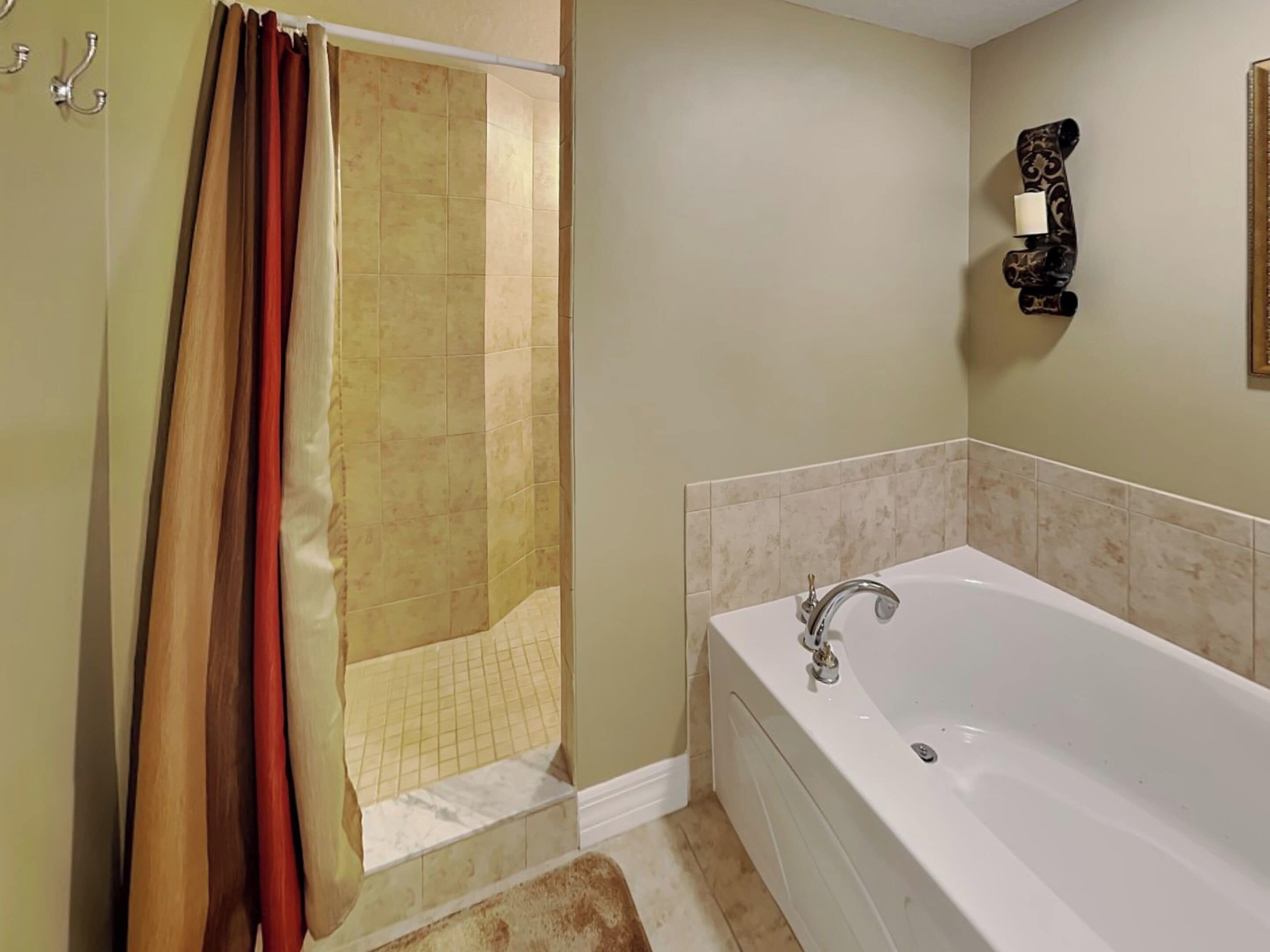 A bathroom with a bathtub, shower curtain, and tiled walls.