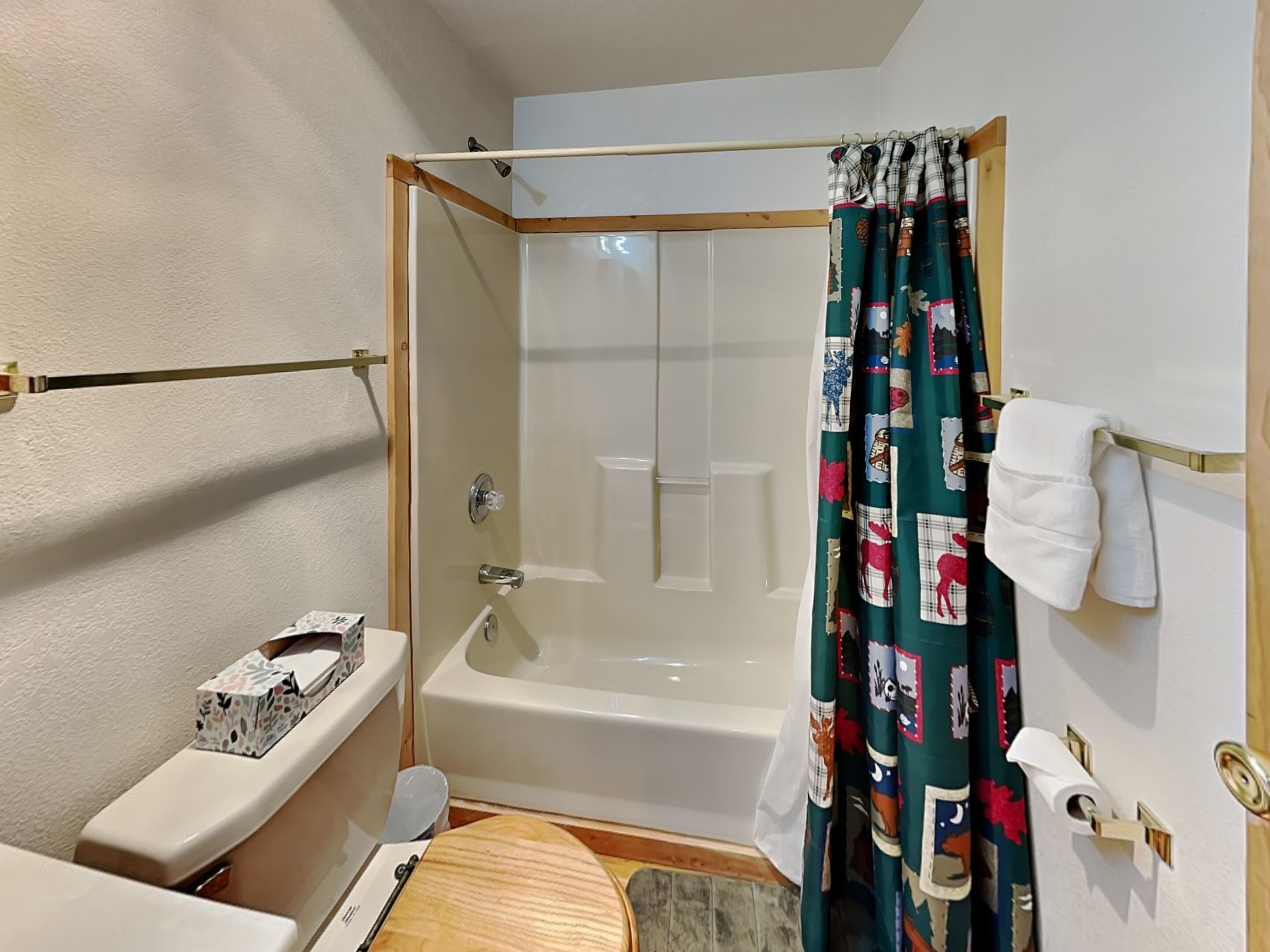 Une petite salle de bain avec un rideau de douche, des toilettes et un lavabo.