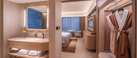 A modern hotel room with a large mirror, a vanity with a sink, a bed with a blue curtain, a TV, and a robe rack.