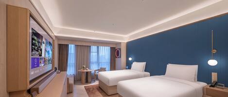A hotel room with two beds, a desk, a TV, and a view of the outside.