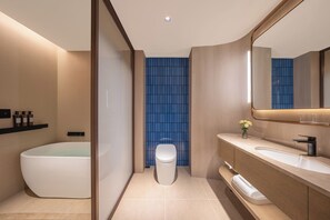 A modern bathroom with a freestanding bathtub, a toilet, and a vanity with a mirror. - Crystal Orange Hotel Suqian Sucheng Government (Suqian)