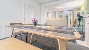 Un espace repas moderne avec une table en bois, des bancs et une plante en pot.
