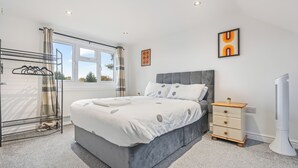 Une chambre à coucher avec un lit, une table de chevet, un radiateur et une fenêtre.