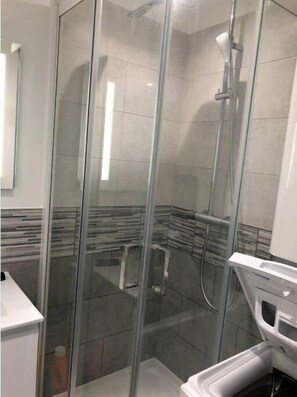 Chuveiro, toalhas de banho, sabonete, papel higiênico