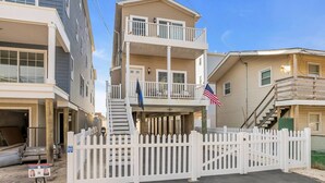 A multi-story residential building with a white picket fence, a balcony, and an American flag. - Bayview Oasis in the Heart of Seaside Heights (Seaside Heights)