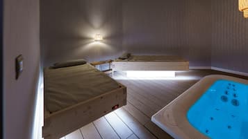 Relax in a serene space with two beds, a hot tub, and comfortable bedside tables.