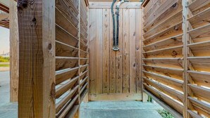 A wooden structure with a central door and a metal pipe running vertically.