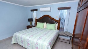 A bedroom with a large bed, a nightstand, a dresser, and a window with curtains. - Stylish Getaway with Private Pool, Fire Pit & Xbox – Walk to the Beach! (Puerto Peñasco)