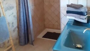 Ein Badezimmer mit Dusche, Waschbecken und Handtuchhalter.