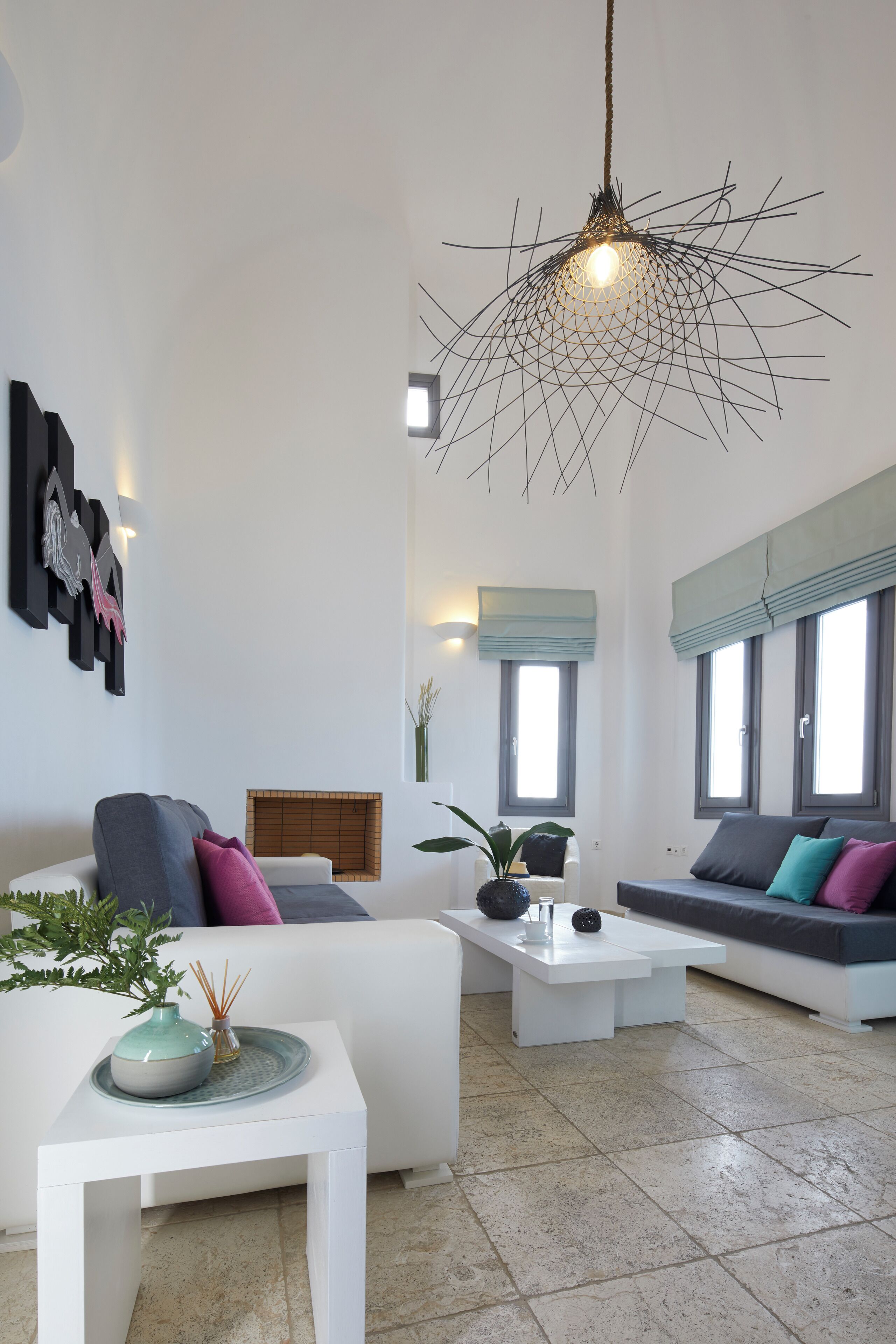 Ein modernes Wohnzimmer mit einem weißen Sofa, einem Couchtisch und einer Pendelleuchte.