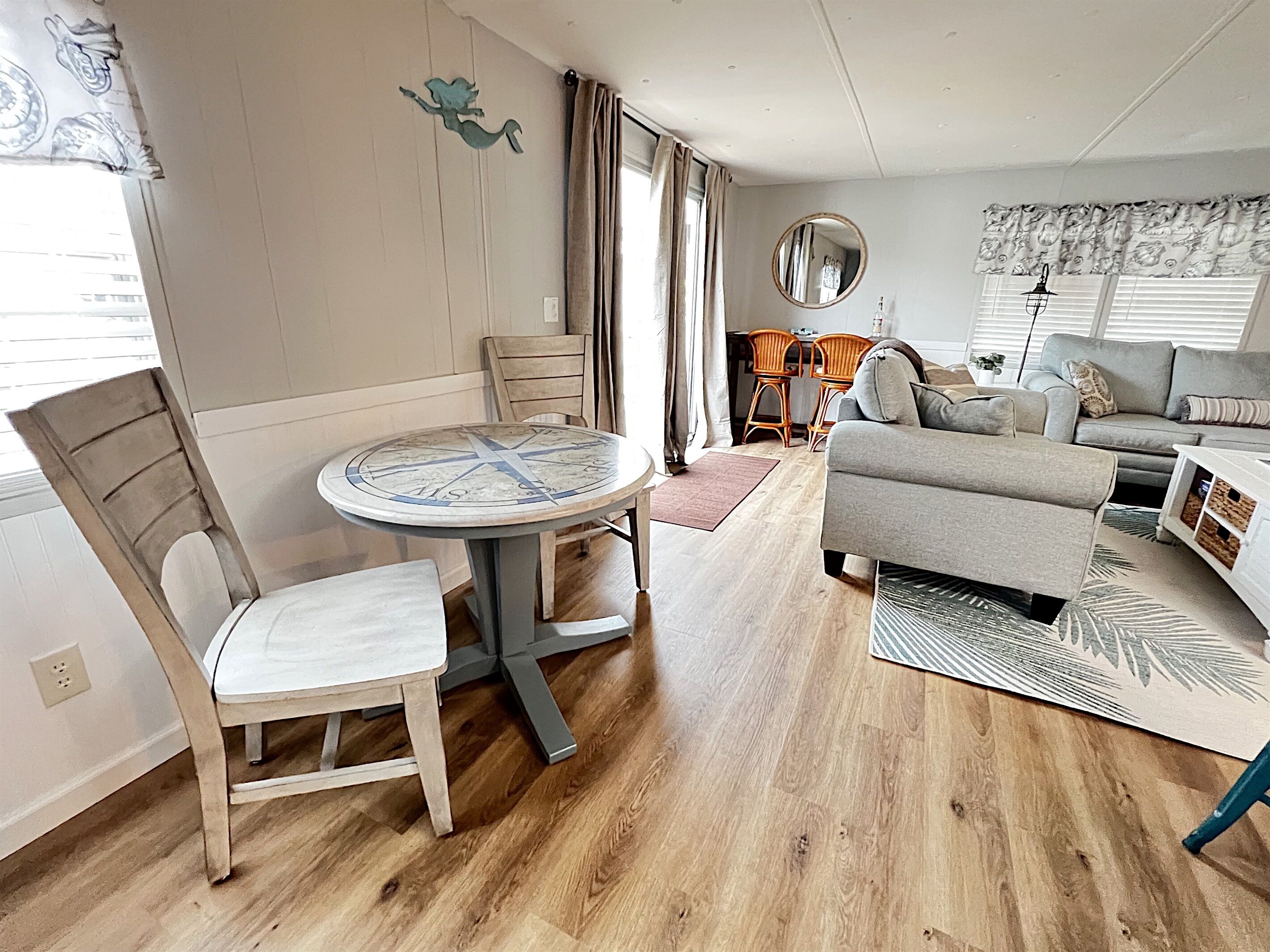 A living room with a round table, a sofa, and a dining area with chairs.