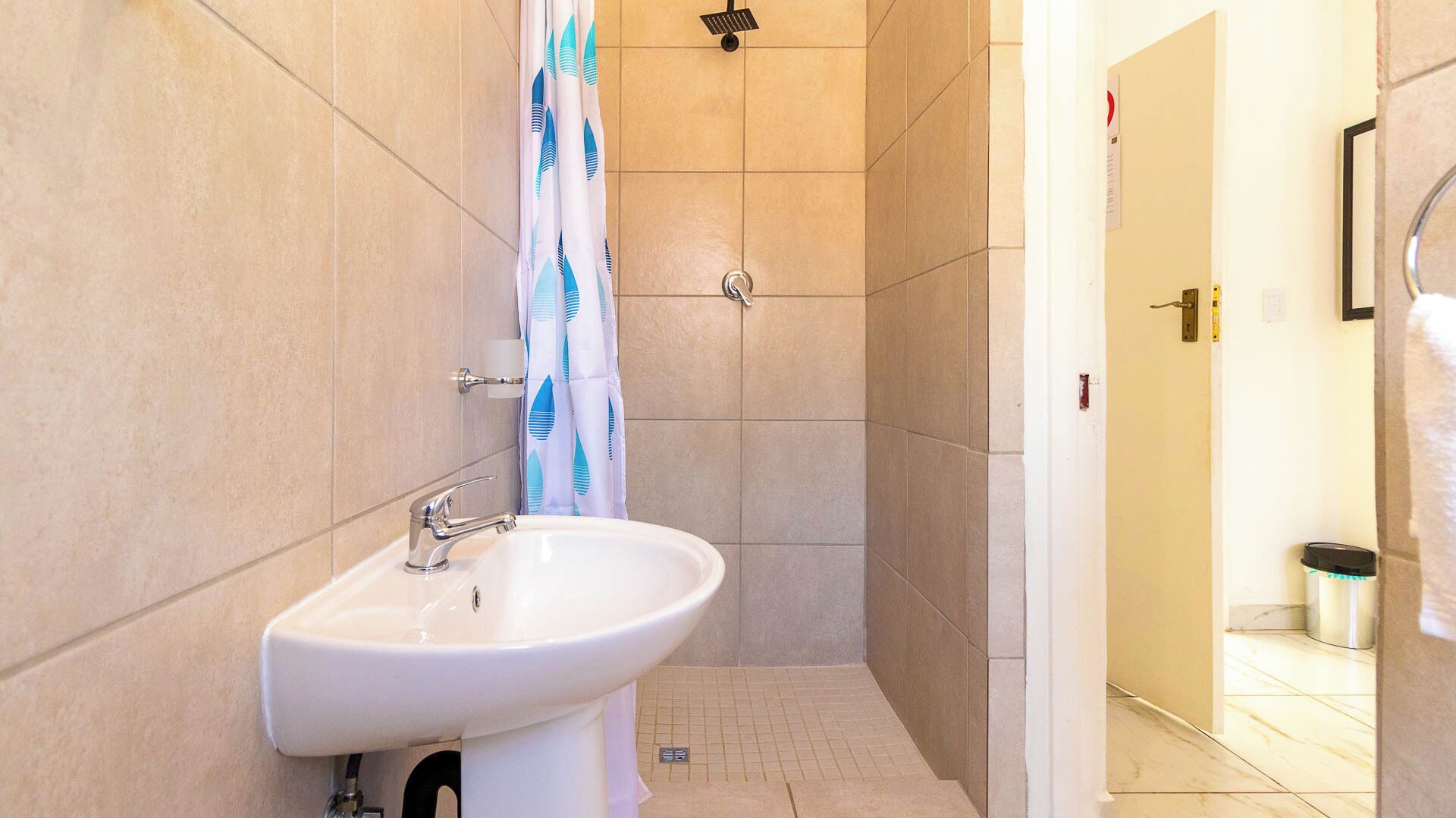 A bathroom with a sink, shower, and toilet.