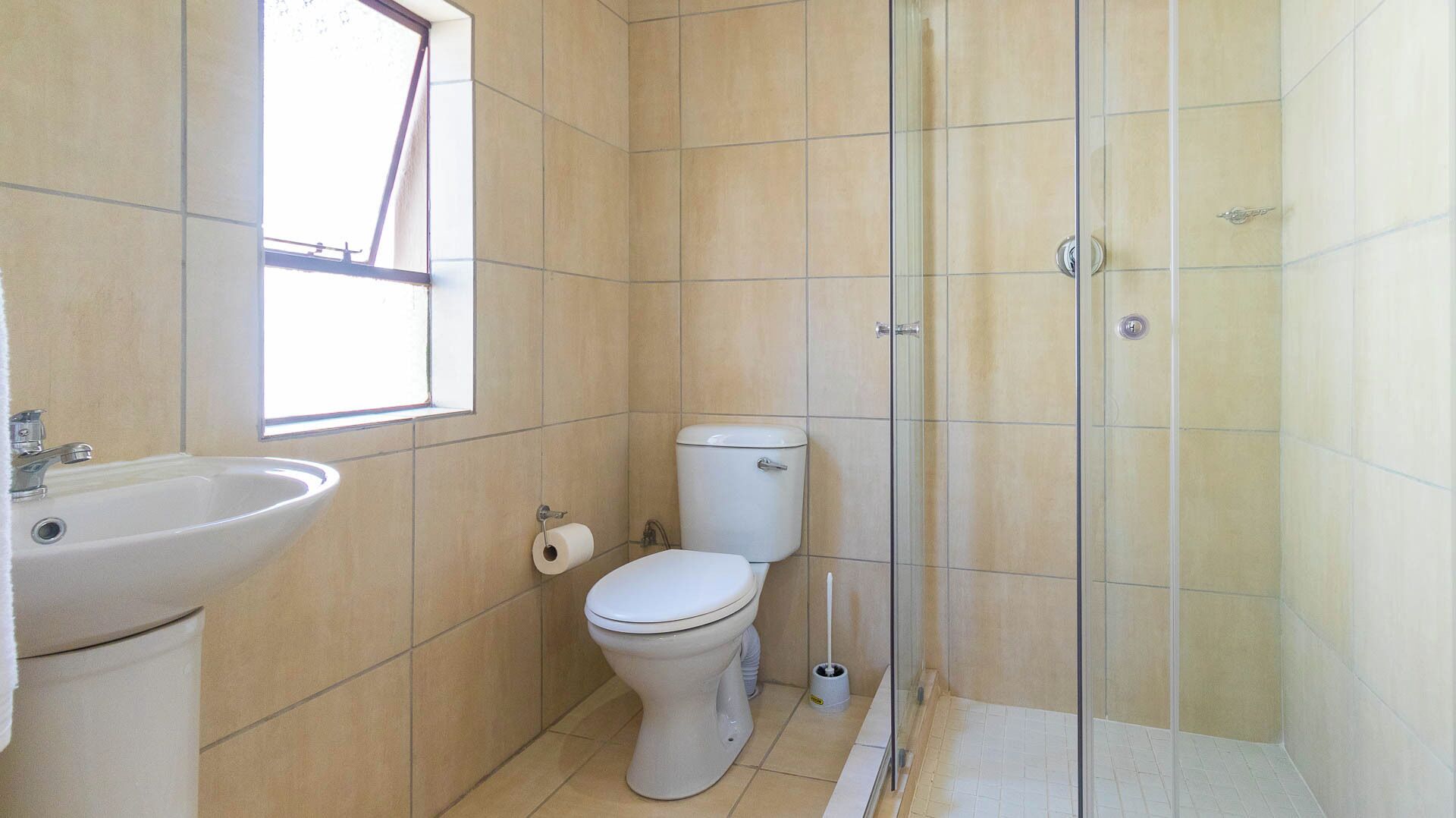 Un baño con inodoro, lavabo y ducha.