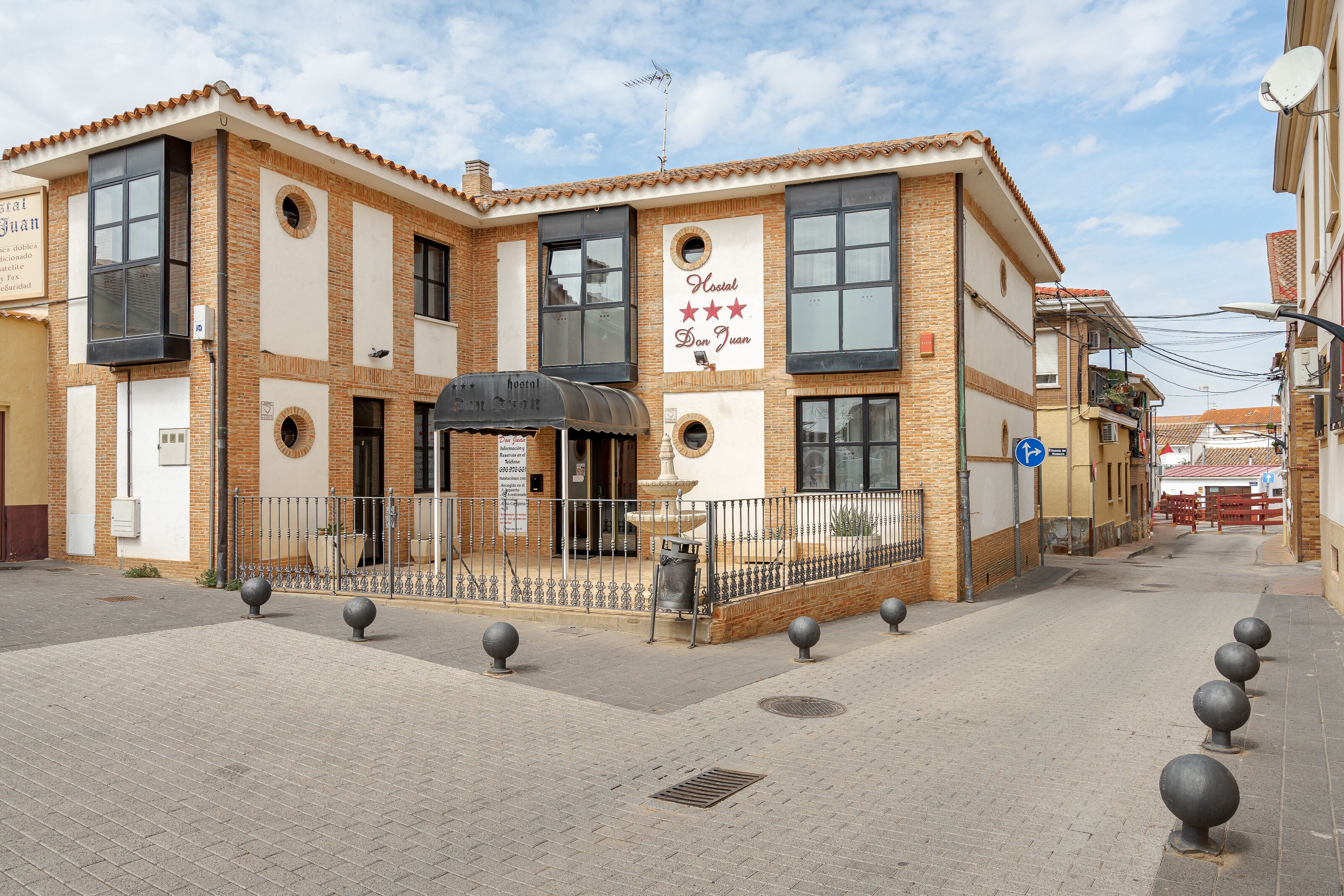 A hotel with a brick facade, large windows, and a sign indicating it is a hotel named "Hotel Don Juan".