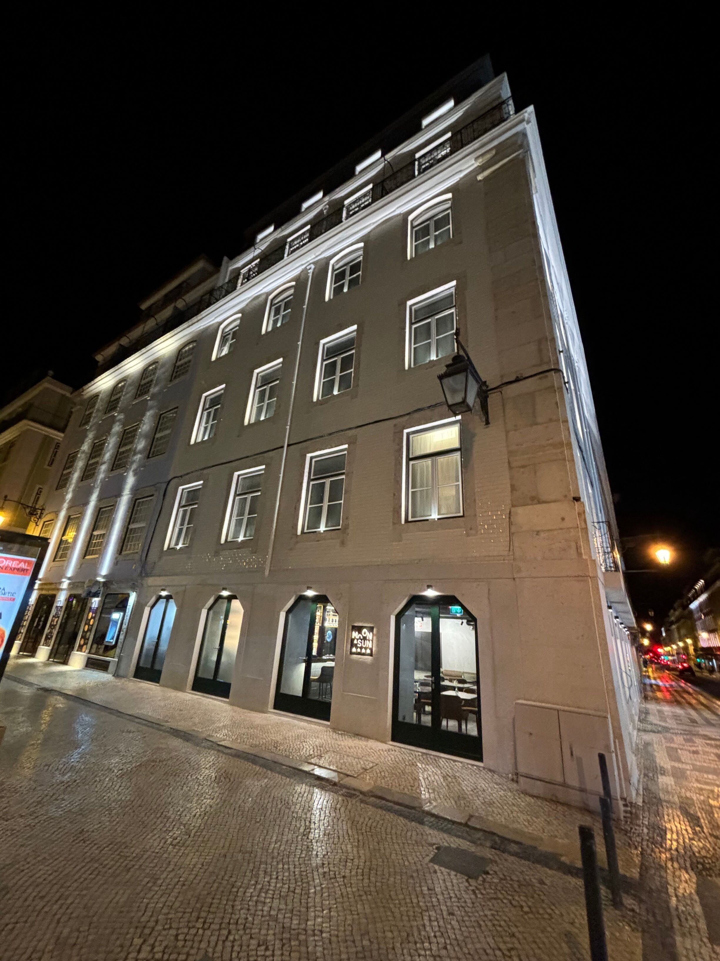 A multi-story building with illuminated windows and a ground-floor entrance.