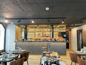Un restaurant doté d’un bar, de tables et de chaises en bois.