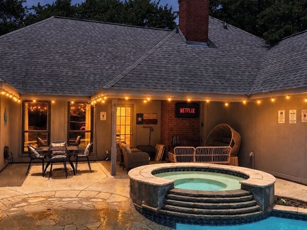 Una casa con piscina, mobiliario de exterior y letrero de Netflix.